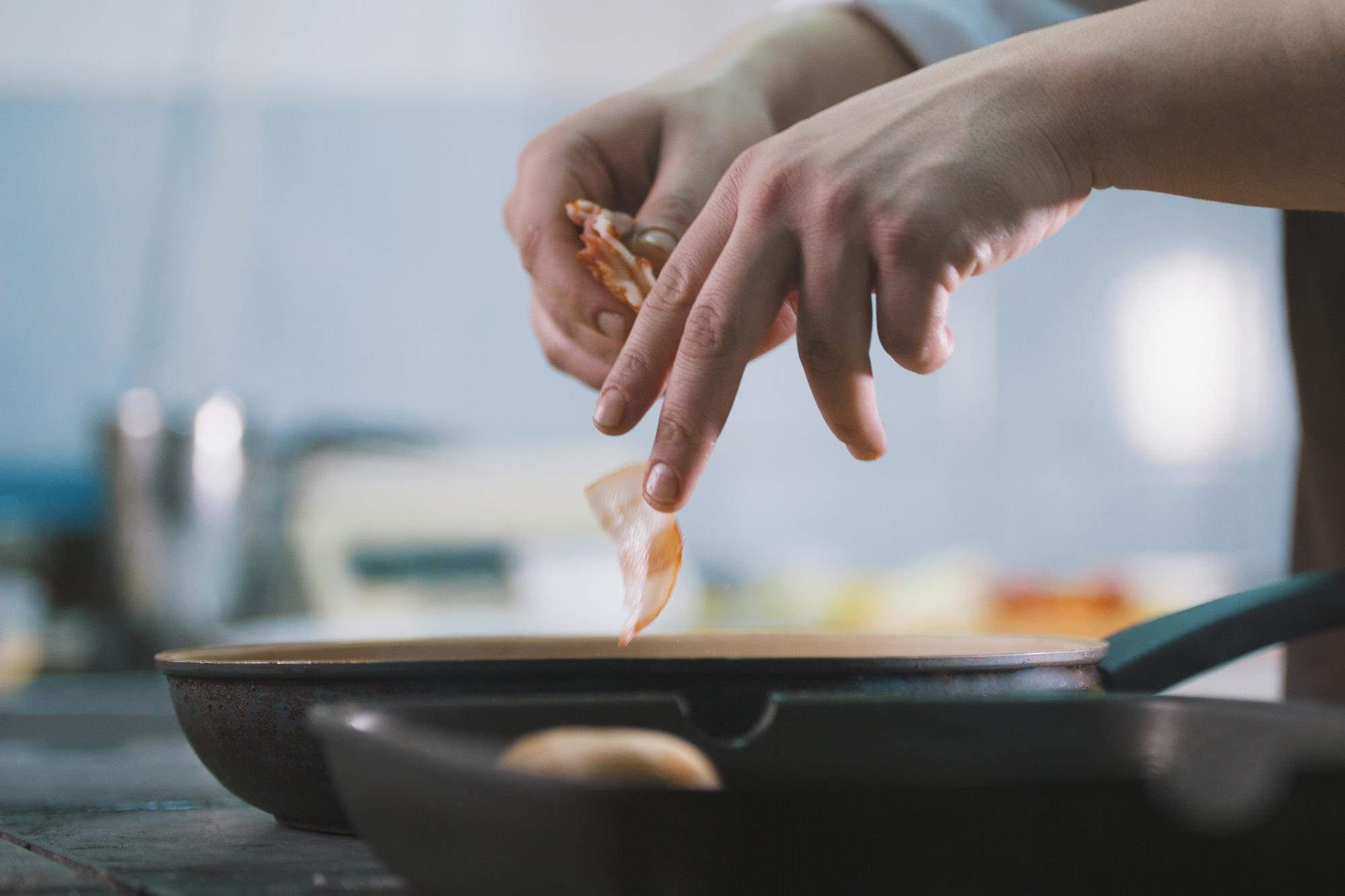 Hands seasoning a pan